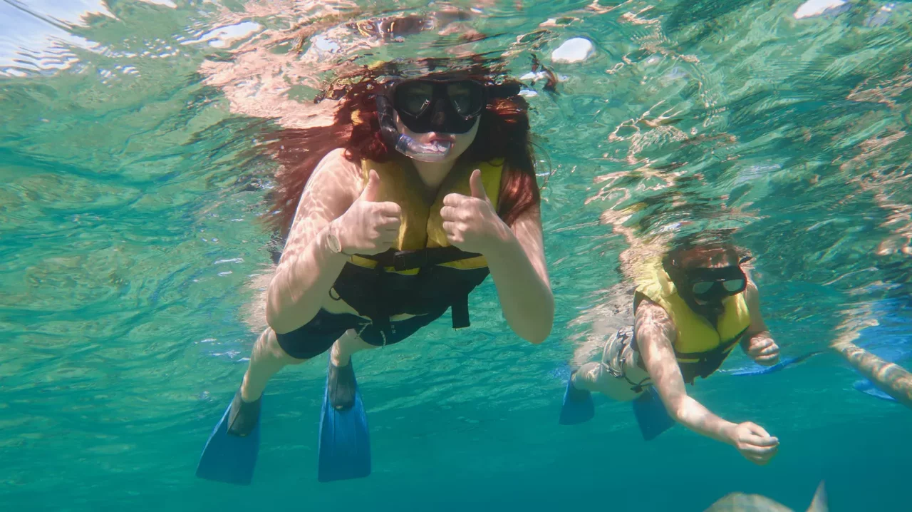 Beginner snorkeler with guide and float vest in calm waters Varadero