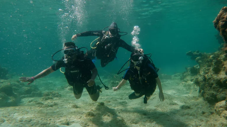 Scuba instructor teaching beginner diver basic skills in shallow water Varadero