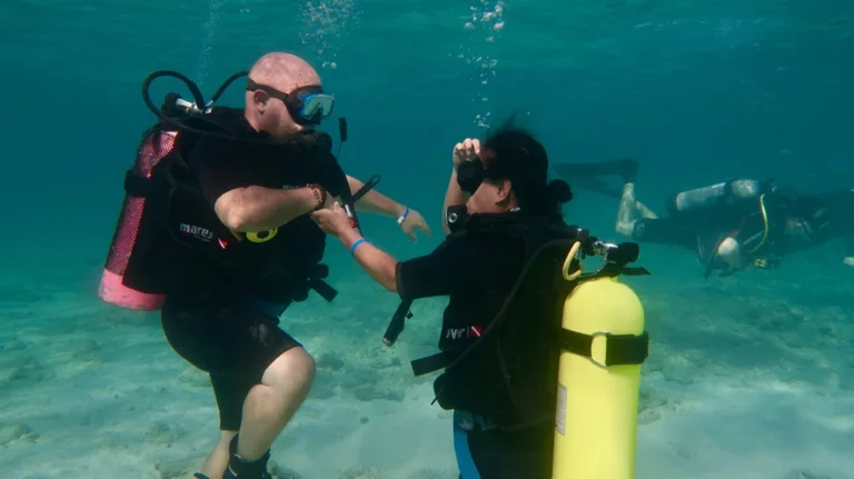 First time scuba diver with instructor holding hand underwater in Varadero Cuba